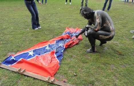 Нарушая табу: датский художник-провокатор разделся догола, выкрасил себя черной краской и сжег флаг Конфедерации