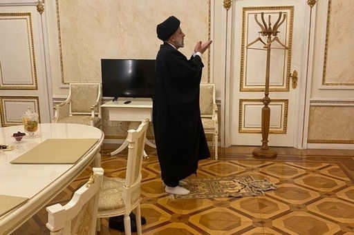Iranian President Raisi prays during talks with Putin in the Kremlin