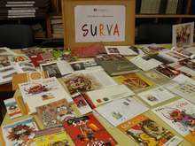 Symbole i materiały reklamowe z festiwalu Surva ułożone w bibliotece Pernik