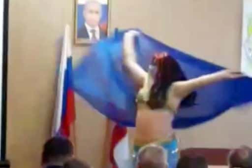 Krim-functionarissen toonden een buikdans tegen de achtergrond van een portret van Poetin