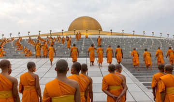 I buddisti thailandesi celebrano il giorno santo in celebrazioni sommesse